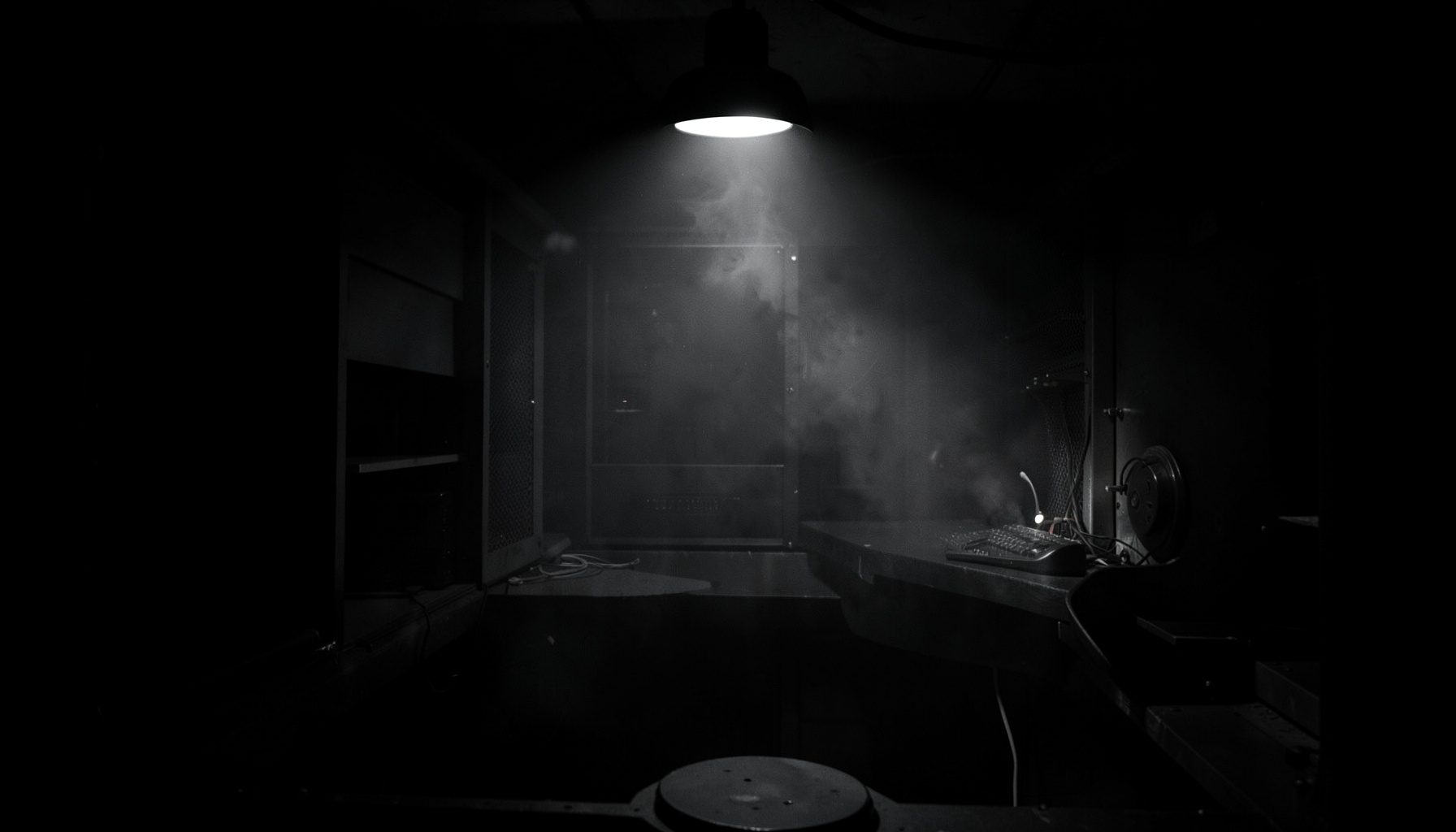 Intérieur sombre d'une tour d'ordinateur ouverte, nuage de poussière éclairé par une lampe frontale, tons noirs et gris.