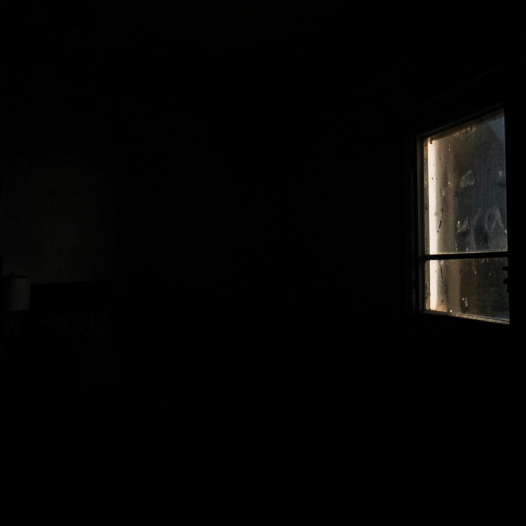 Photographie sombre d'un montage de table de mixage, ambiance technique et feutrée aux tons foncés