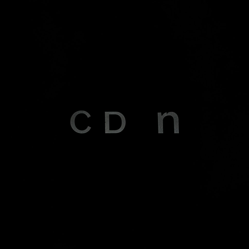 Logo circulaire sombre aux accents rouge profond et or, ambiance graphique et sobre.